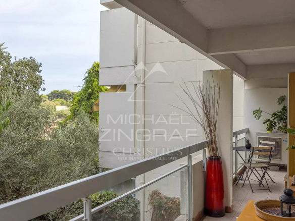 Balcon d'un appartement au Cap d'Antibes avec vue sur un parc arboré.