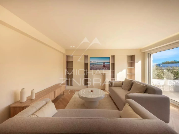 Bright living room in a renovated apartment with bay windows and terrace view in Antibes.