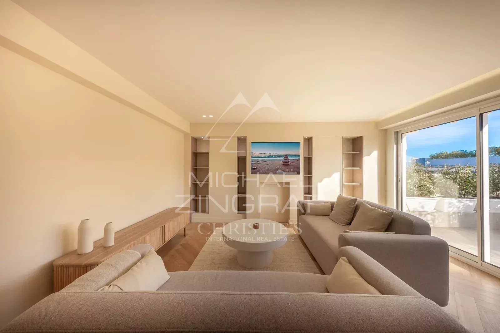 Bright living room in a renovated apartment with bay windows and terrace view in Antibes.