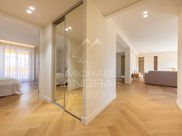 Interior of a renovated 100 m² apartment in Antibes, showing a hallway and a bright living room.