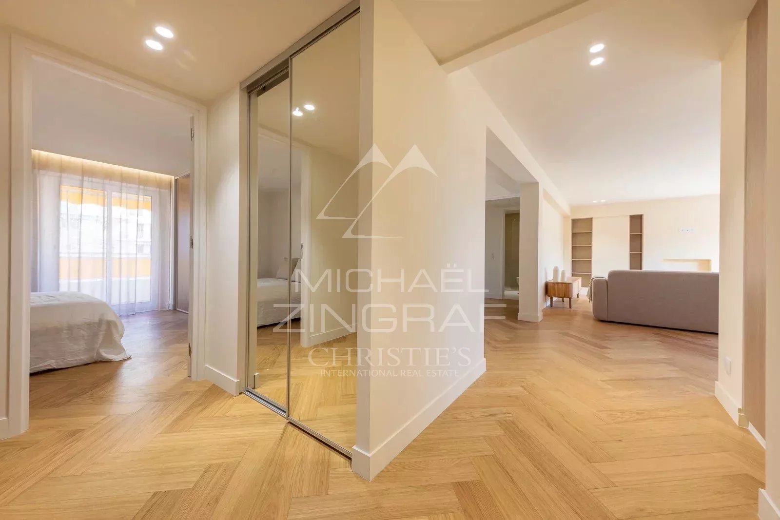 Interior of a renovated 100 m² apartment in Antibes, showing a hallway and a bright living room.