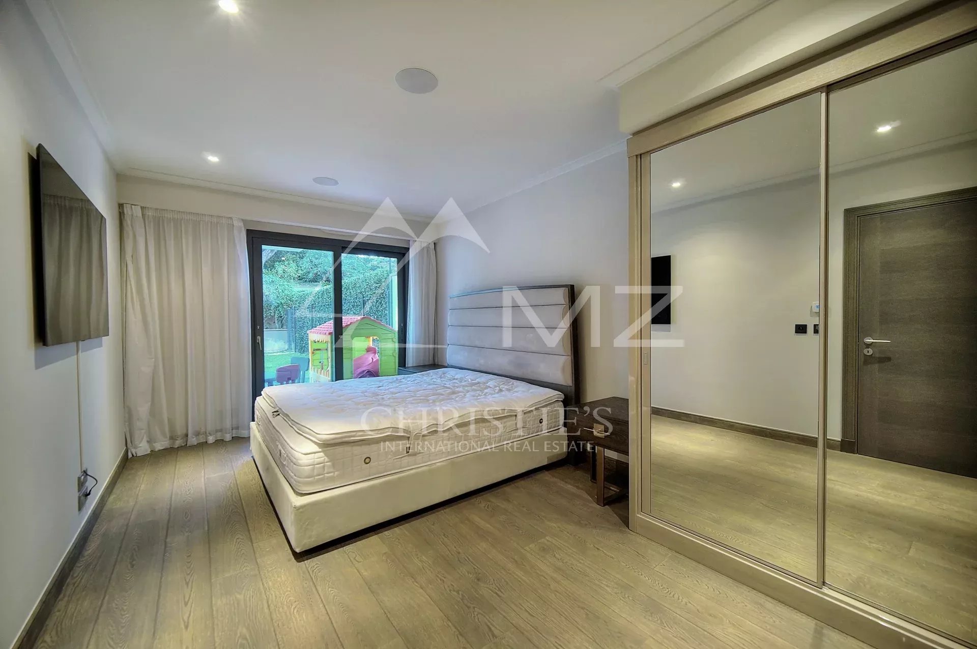Chambre d’appartement au Parc du Cap Chambre d'un appartement à vendre au Parc du Cap à Antibes, avec lit et accès à un jardin.