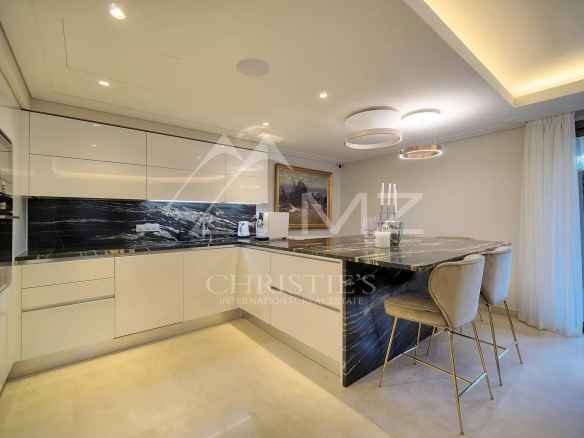 Cuisine moderne d'un appartement rez-de-jardin à Antibes, avec un îlot central et des équipements haut de gamme.