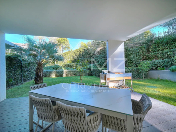 Terrasse d'un appartement avec mobilier de jardin et jardin verdoyant à Antibes.