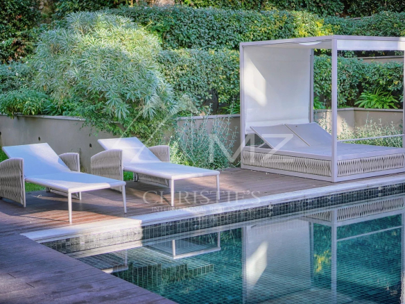 Chaises longues et lit de jardin au bord de la piscine dans un complexe résidentiel à Antibes.