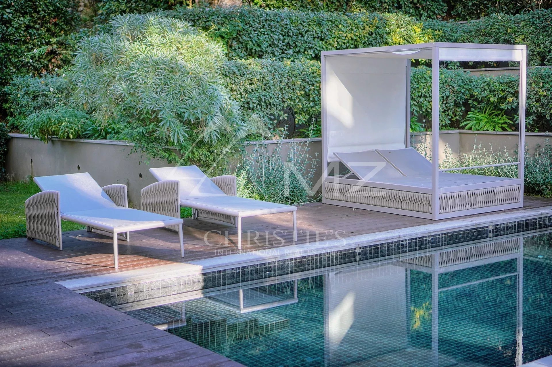 Espace détente au bord de la piscine Chaises longues et lit de jardin au bord de la piscine dans un complexe résidentiel à Antibes.