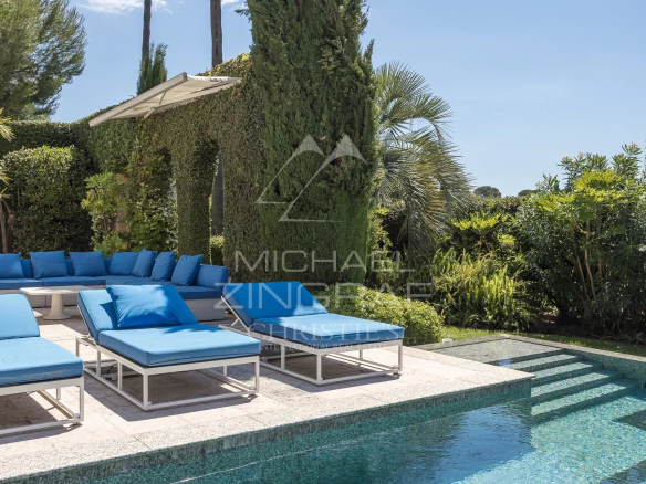 View of the swimming pool and sun loungers in a landscaped garden in Cap d'Antibes.