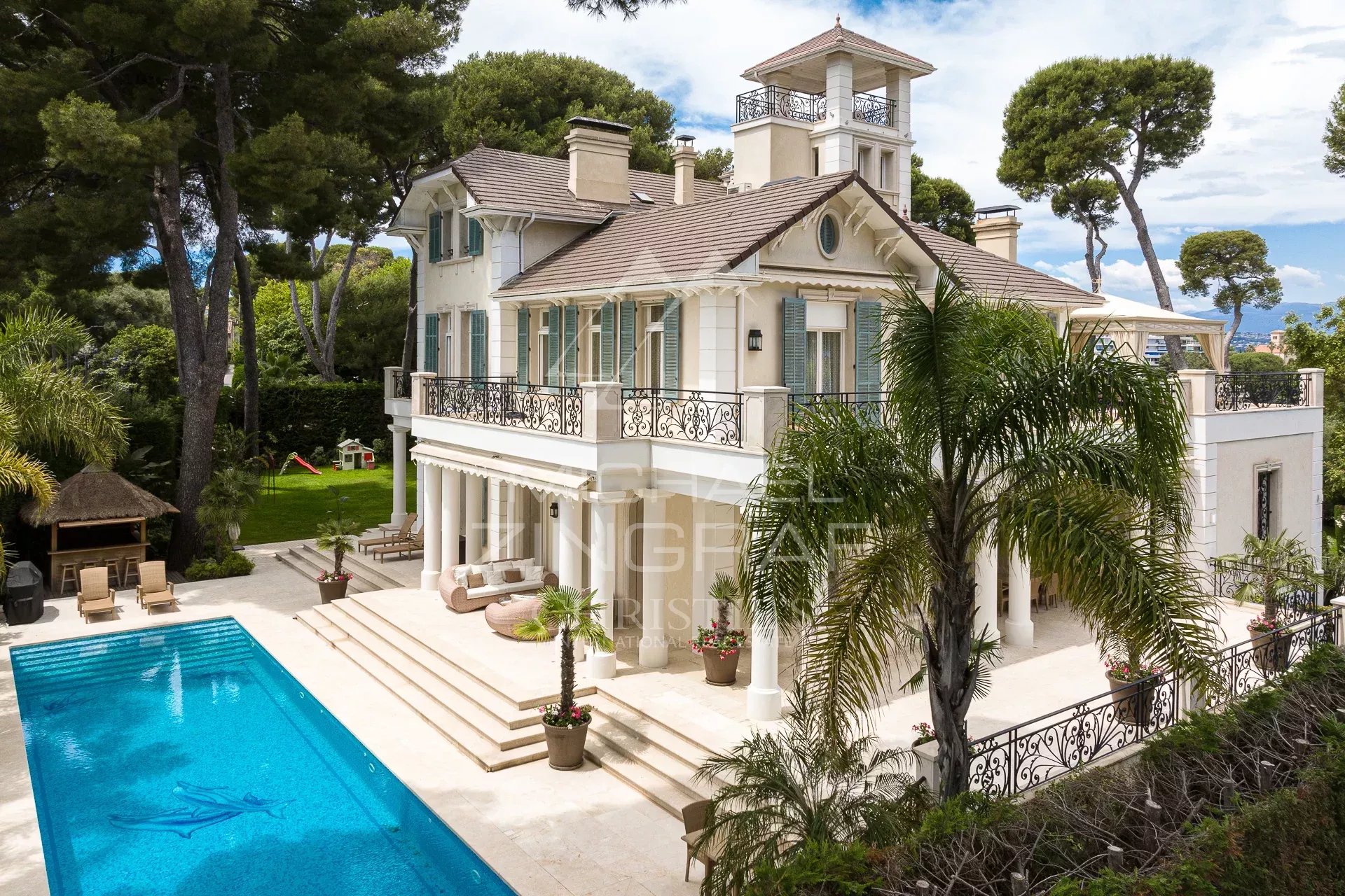 Belle Époque style property with swimming pool in Cap d'Antibes, surrounded by greenery.