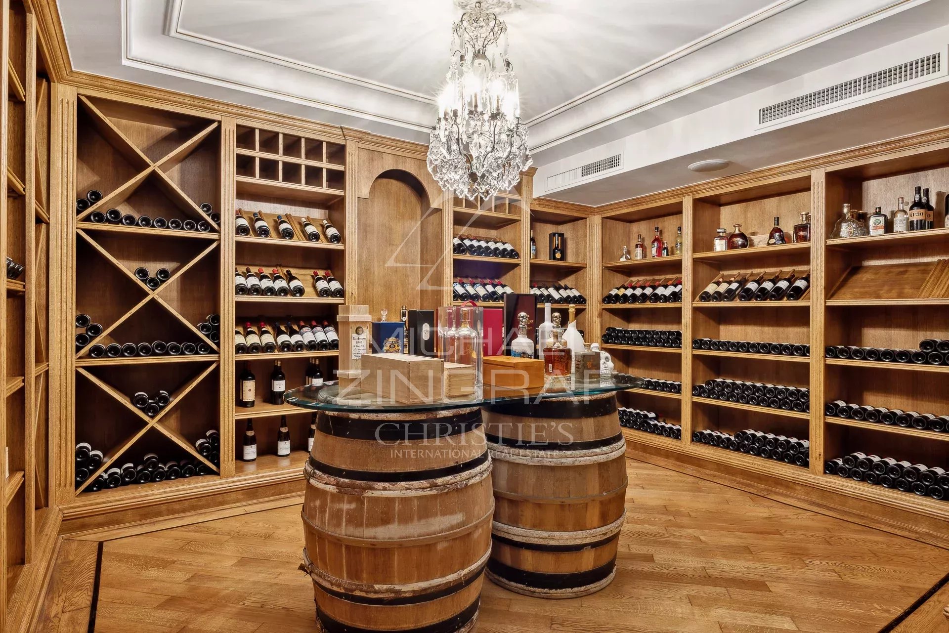 Wooden wine cellar with bottles, decorated with a chandelier, in a Belle Époque style property in Antibes.