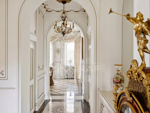 Interior of a Belle Époque style property with a decorated hallway and a chandelier.