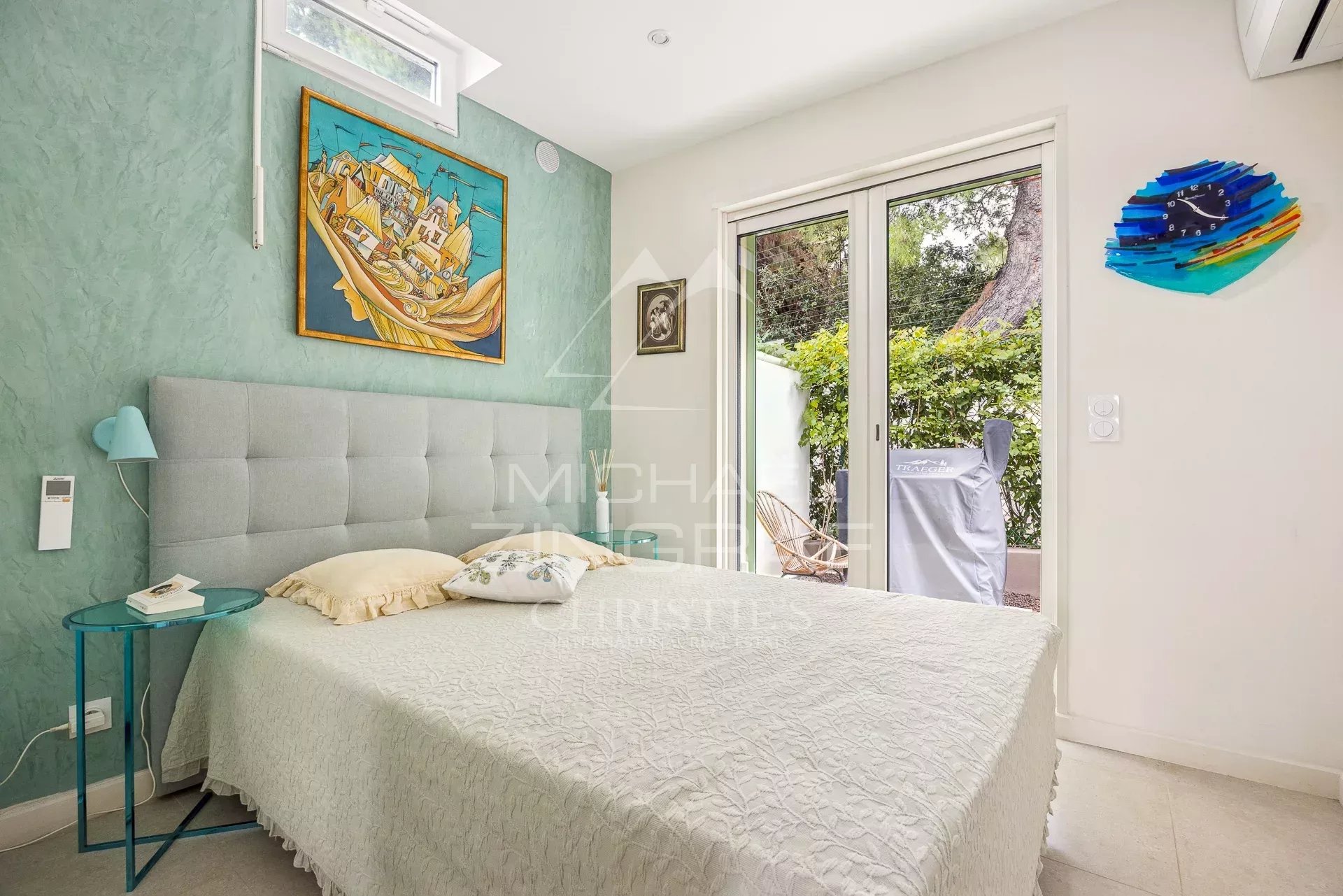 Chambre lumineuse avec lit double et accès à un jardin, décorée de manière moderne.