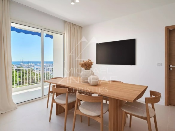 Intérieur d'un appartement à Cannes avec vue sur la mer, salle à manger moderne et balcon.