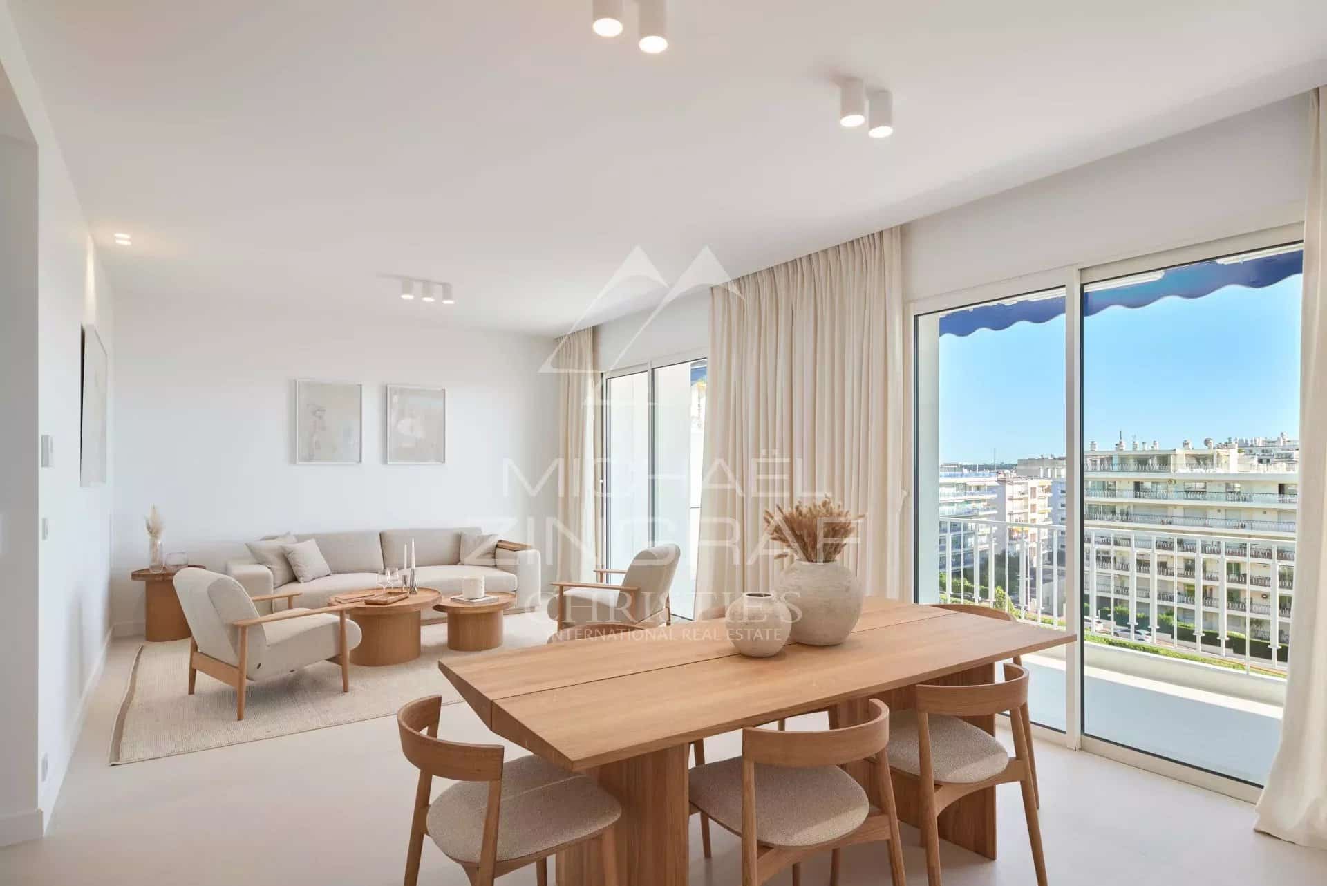 Intérieur d'un appartement moderne avec vue sur la mer à Cannes, mobilier contemporain et espace lumineux.