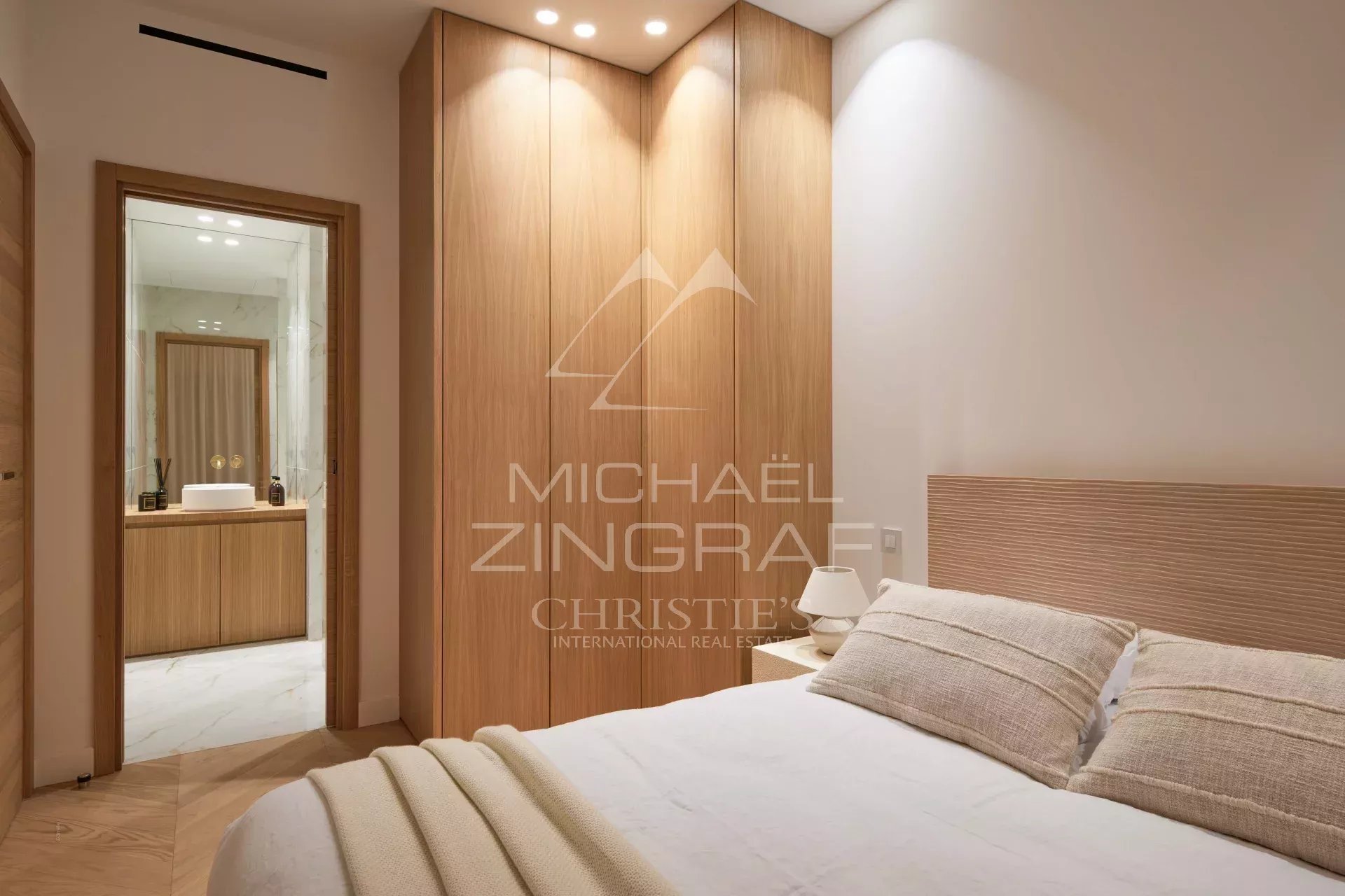 Chambre d'un appartement rénové à Cannes, avec lit et mobilier moderne.