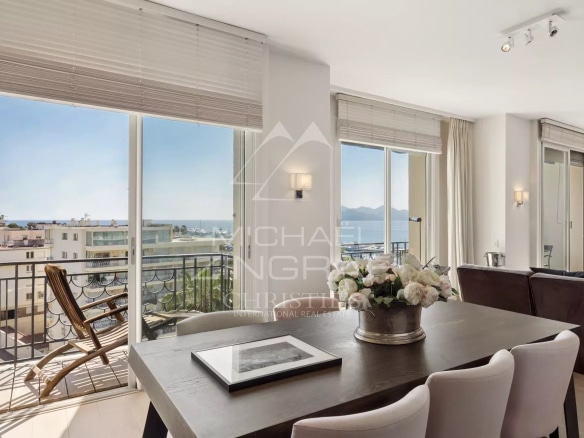 Interior of a penthouse in Cannes with sea view, bright dining room and balcony.