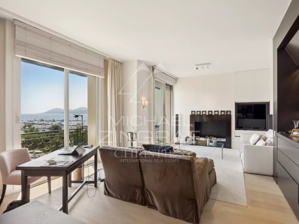 Interior of a penthouse in Cannes with sea view, bright living room and balcony.