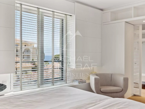 Chambre d'un appartement à Cannes avec vue sur la mer, décorée dans un style moderne et épuré.