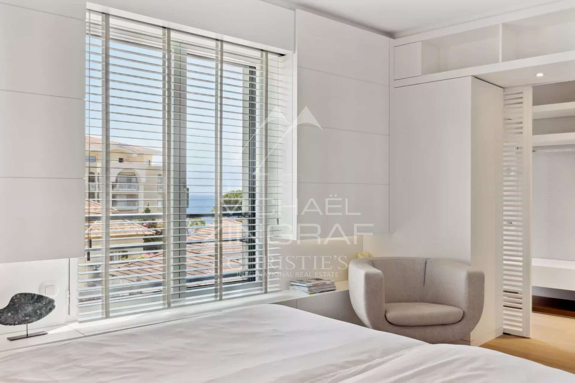 Chambre d'un appartement à Cannes avec vue sur la mer, décorée dans un style moderne et épuré.