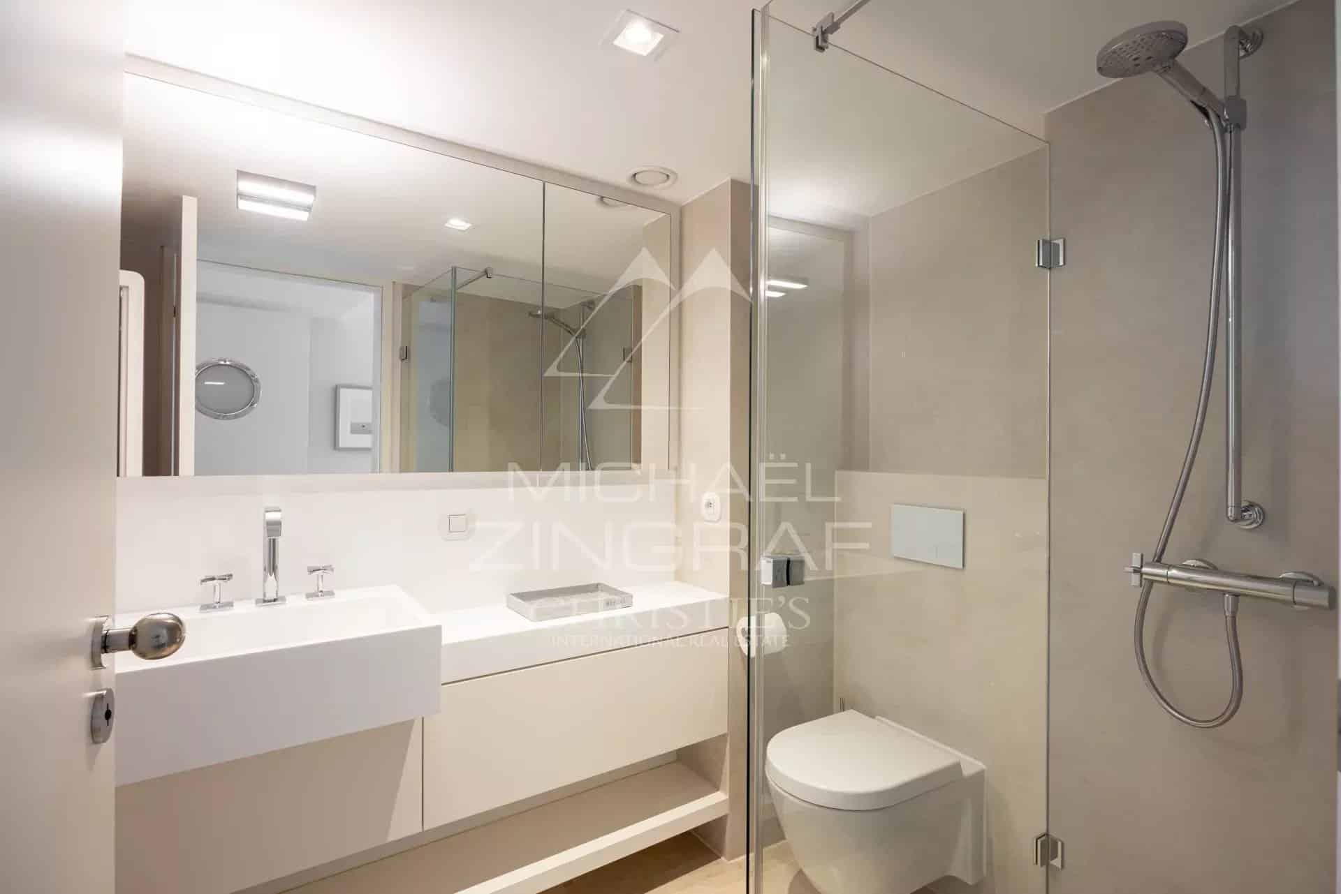 Salle de bain moderne avec douche, lavabo et toilettes dans un appartement à Cannes.