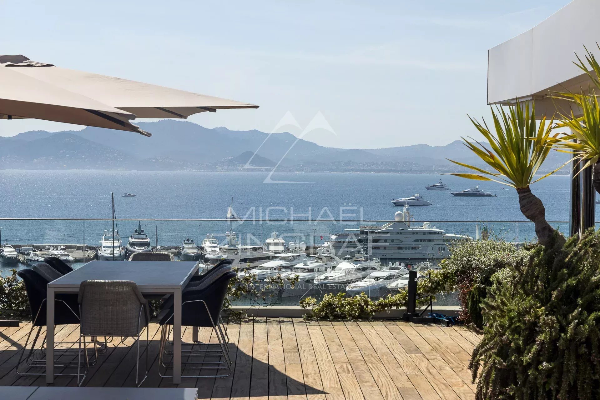 Penthouse with panoramic sea views in Cannes, wooden terrace and outdoor furniture.