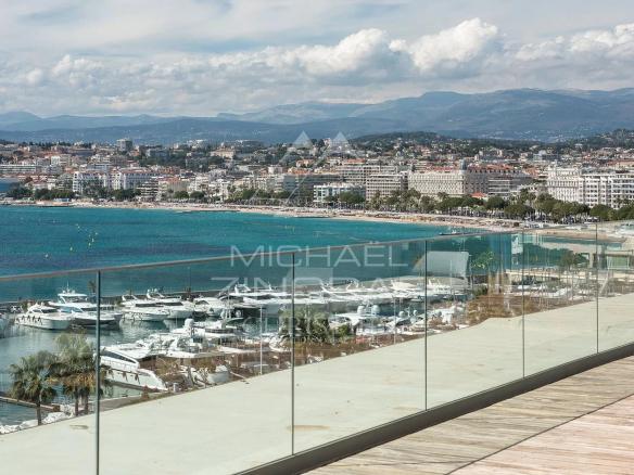Panoramic sea view from a penthouse in Cannes, with yachts in the port and beaches in the background.