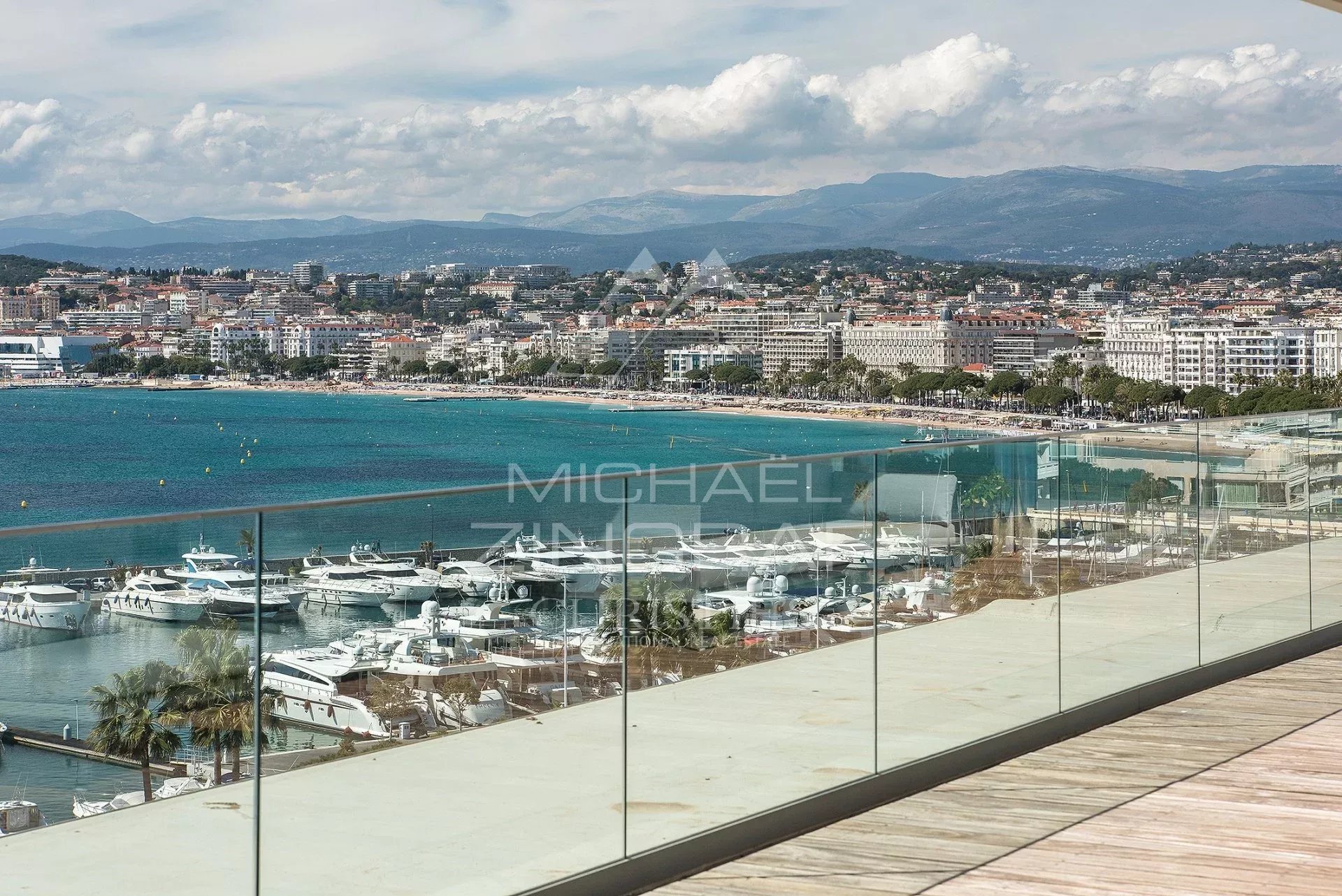 Panoramic sea view from a penthouse in Cannes, with yachts in the port and beaches in the background.
