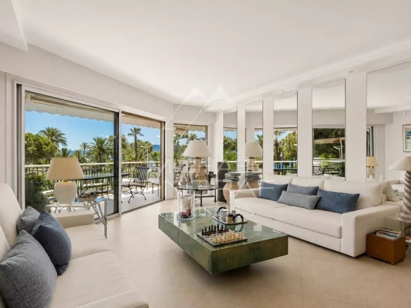 Salon lumineux d'un appartement à Cannes avec terrasse et vue sur la verdure.
