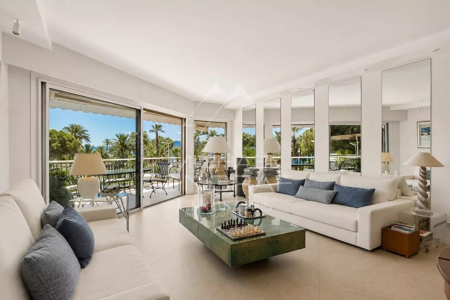 Salon lumineux d'un appartement à Cannes avec terrasse et vue sur la verdure.