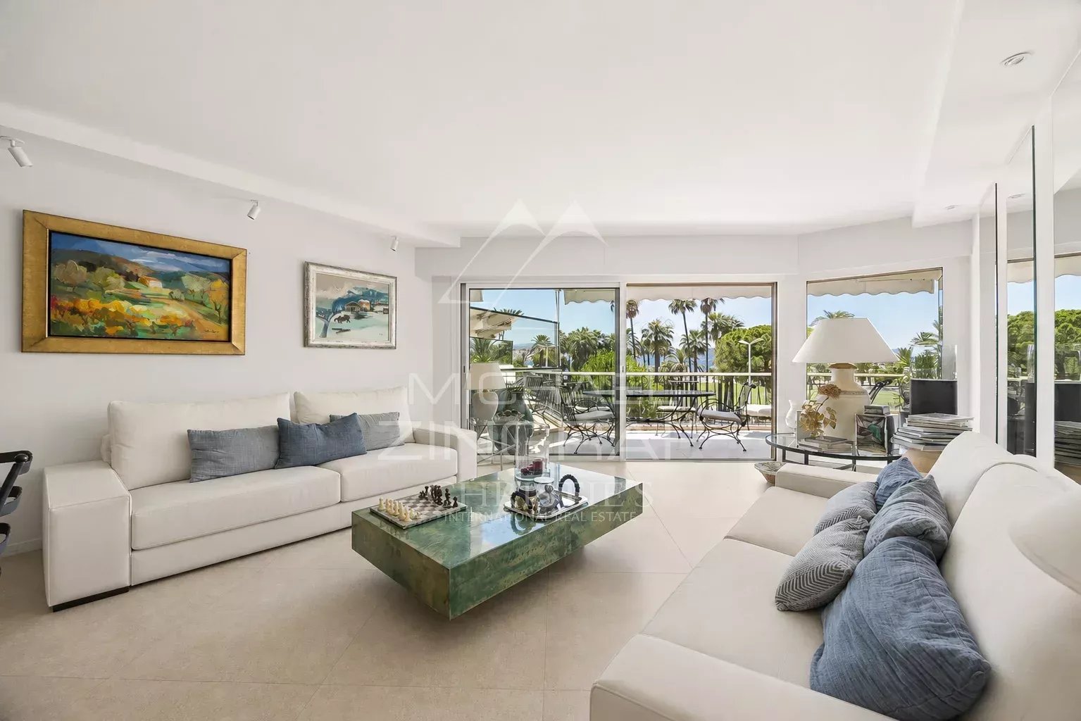 Intérieur d'un appartement moderne avec salon lumineux et vue sur la terrasse à Cannes.