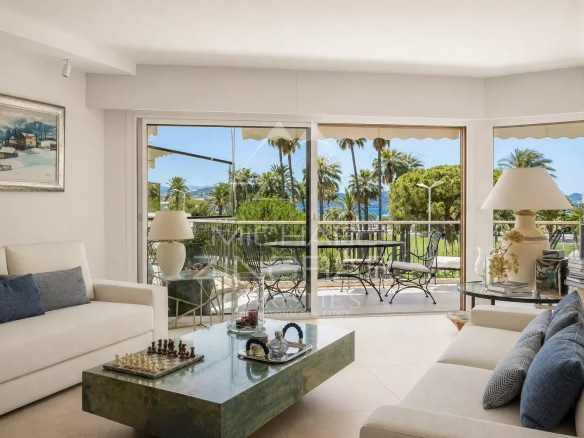 Salon lumineux d'un appartement à Cannes avec vue sur la mer et la Croisette.
