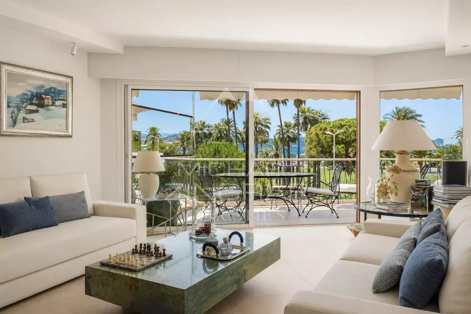 Salon lumineux d'un appartement à Cannes avec vue sur la mer et la Croisette.