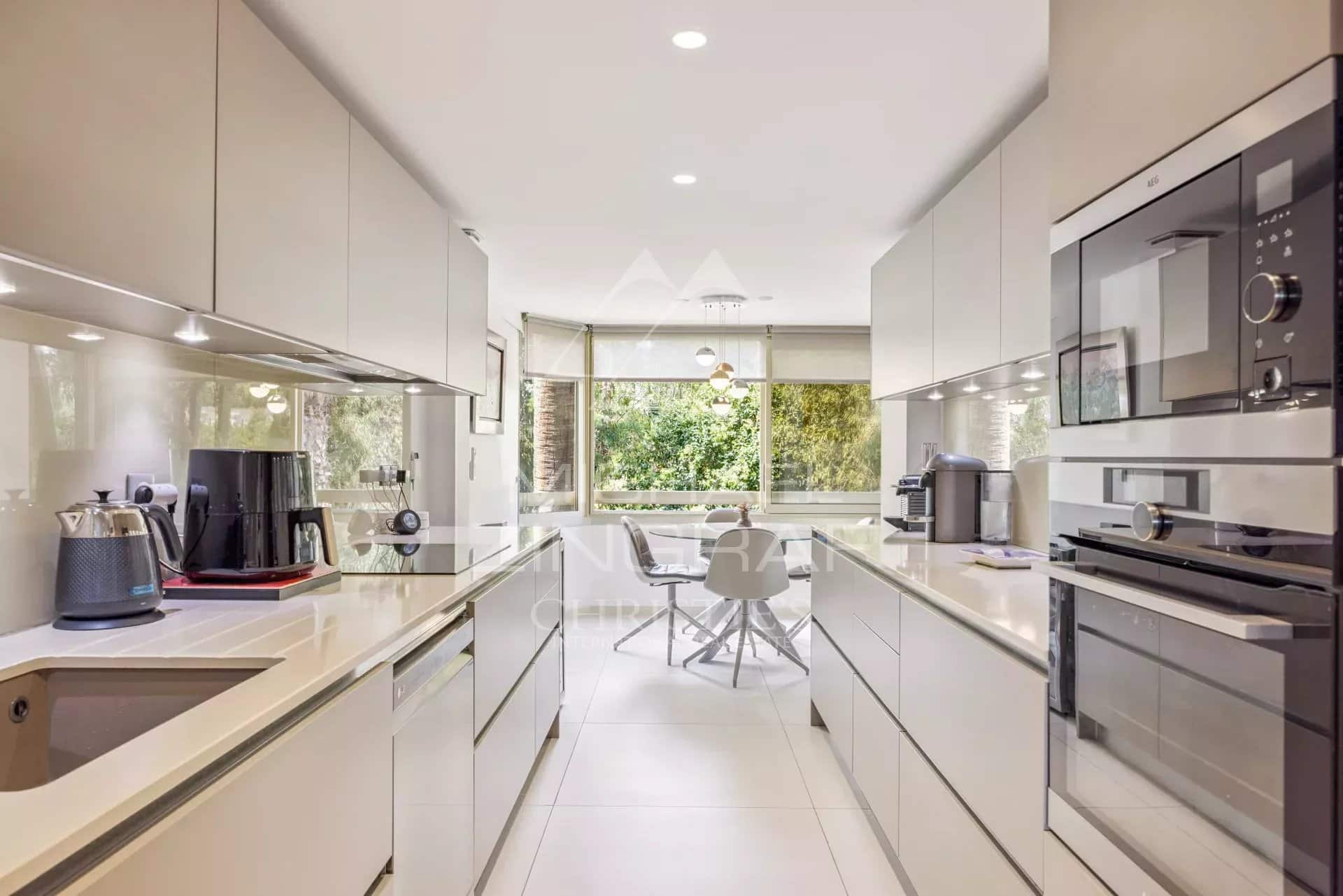 Modern and bright kitchen in an apartment in Cannes, with high-end equipment and dining area.