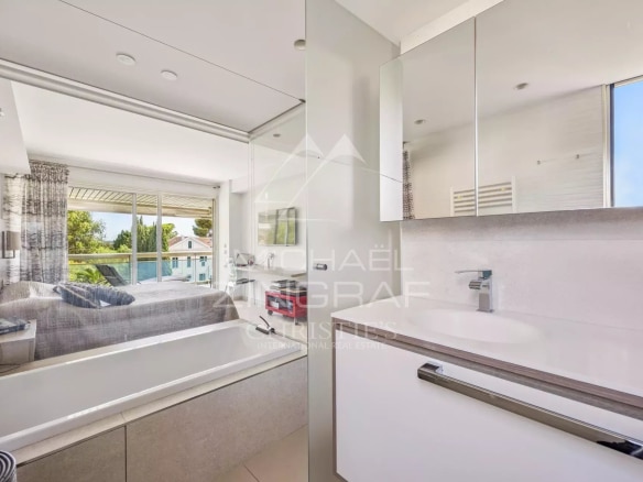 Modern bathroom with bathtub and view of a bright space.