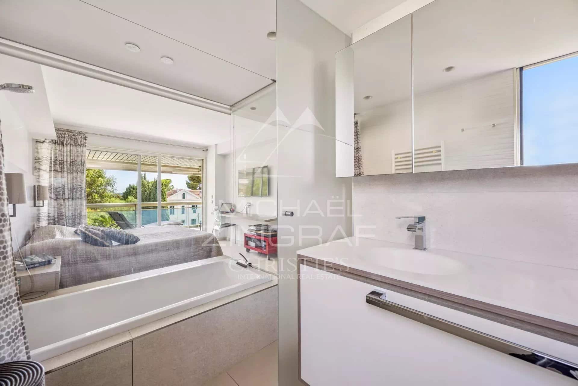 Modern bathroom with bathtub and view of a bright space.
