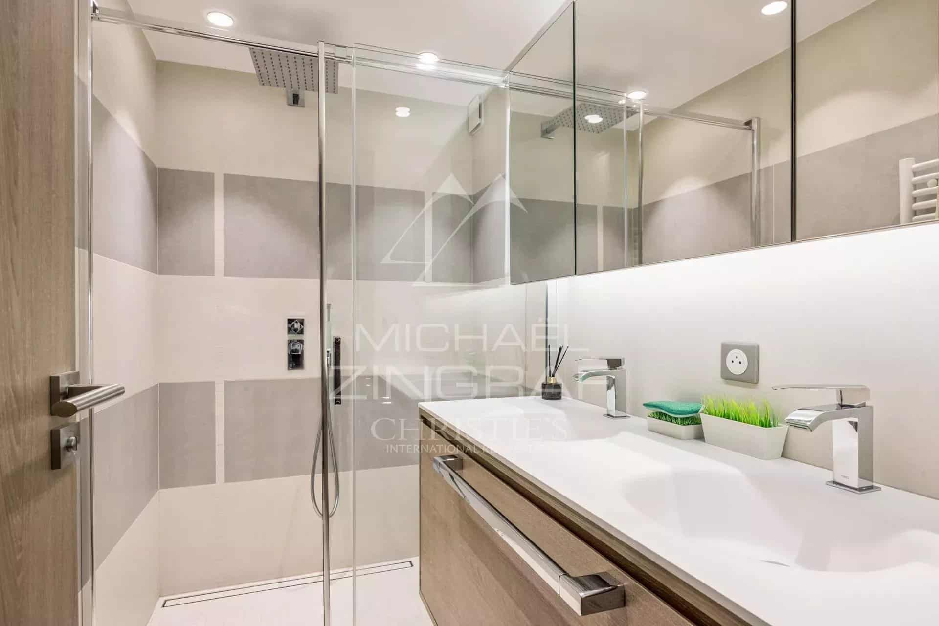 Modern bathroom with walk-in shower and wooden vanity unit.
