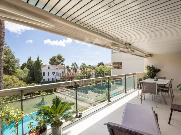 Terrace of an apartment in Cannes overlooking the swimming pool and green spaces.