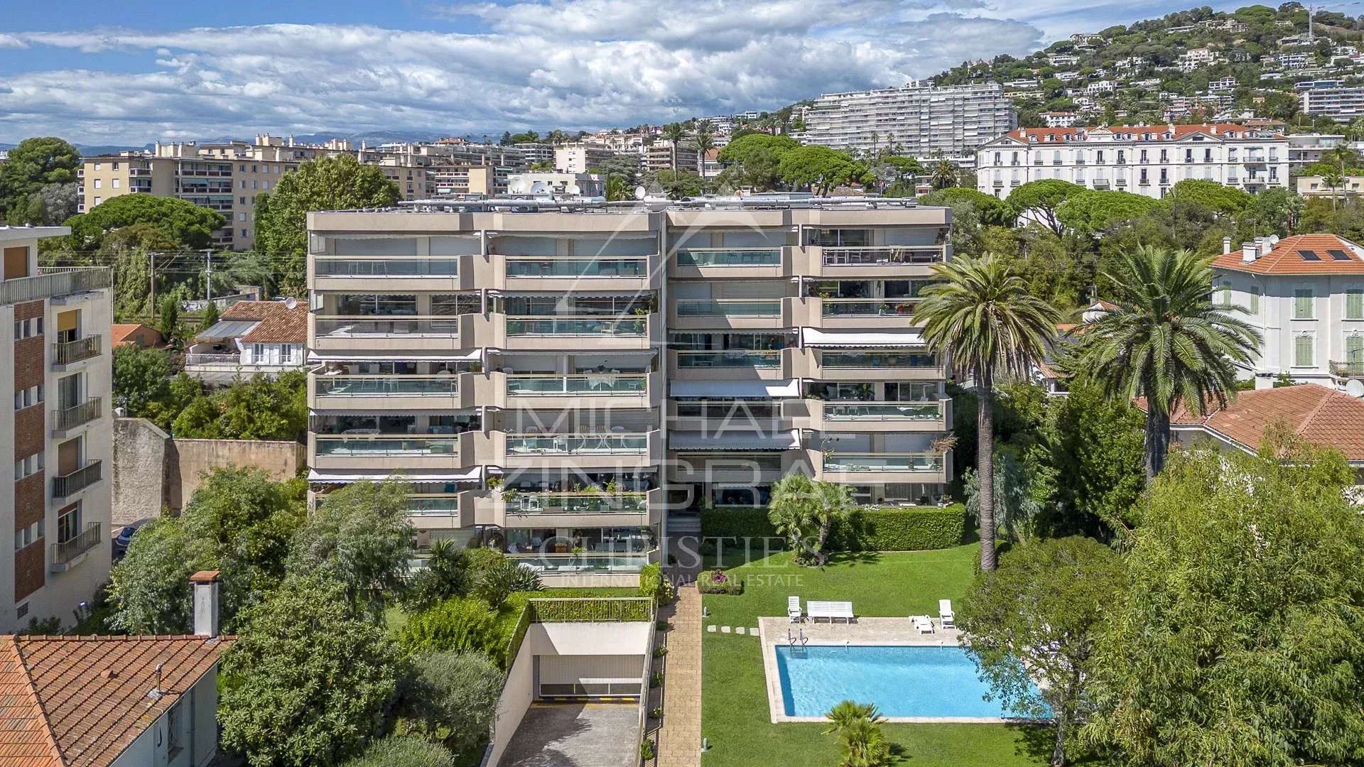 Aerial view of a modern building with swimming pool and gardens in Cannes, Palm Beach district.