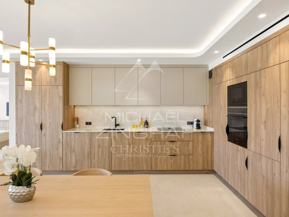 Cuisine moderne et élégante d'un appartement à Cannes, avec mobilier en bois et table à manger.