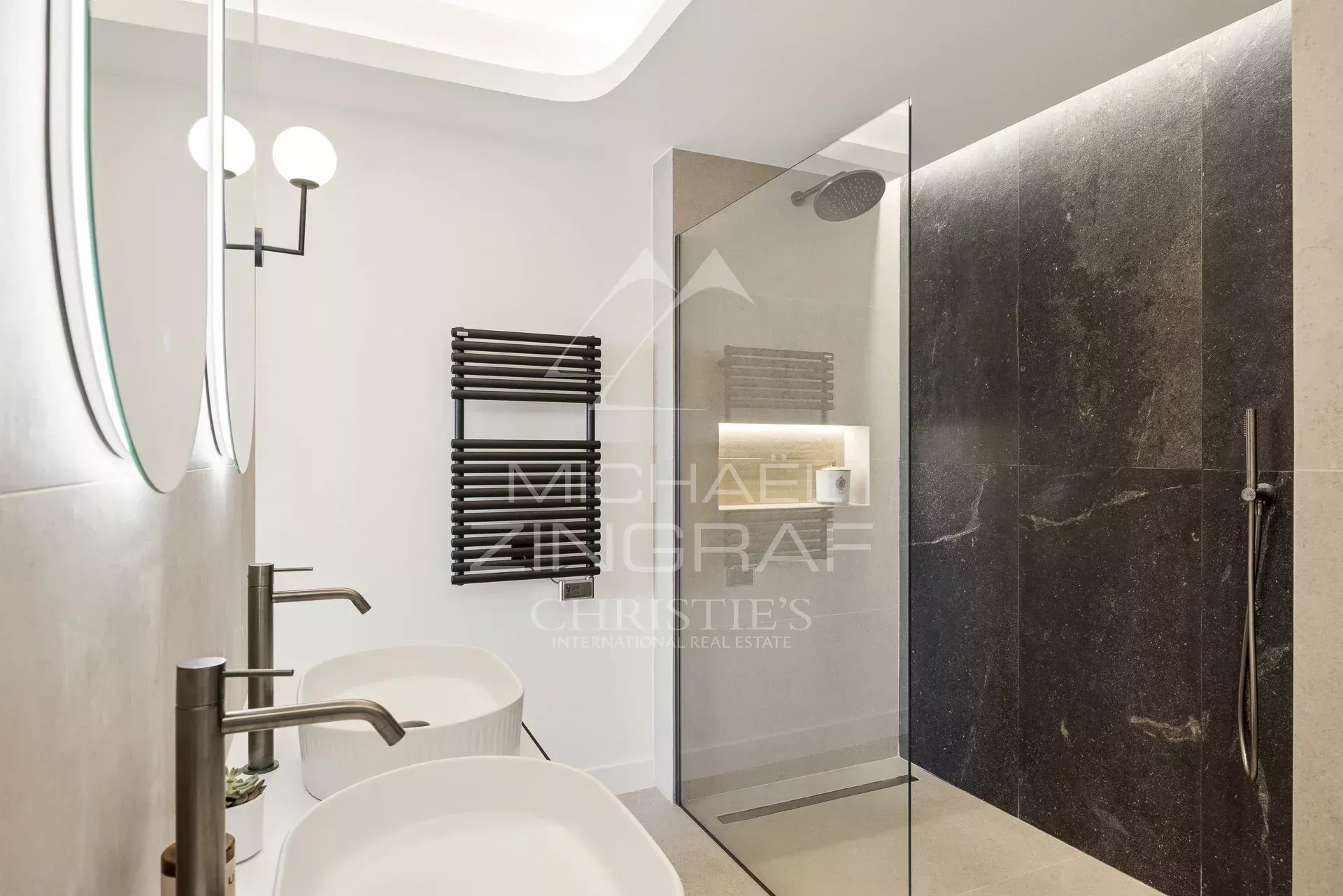 Salle de bain d’un appartement à Palm Beach Salle de bain moderne avec douche en verre et vasques doubles dans un appartement rénové.
