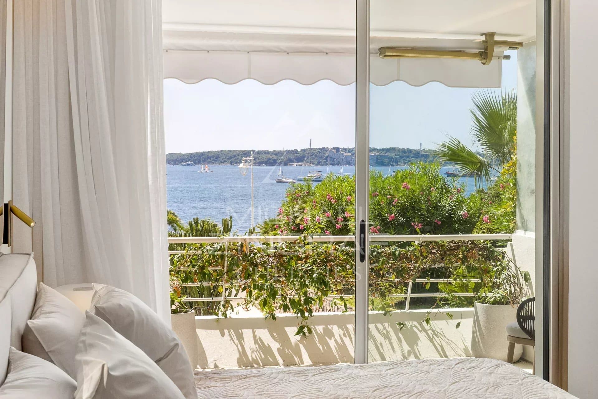 Vue panoramique depuis l’appartement à Palm Beach Vue depuis une chambre d'un appartement à Palm Beach, avec mer et végétation en arrière-plan.