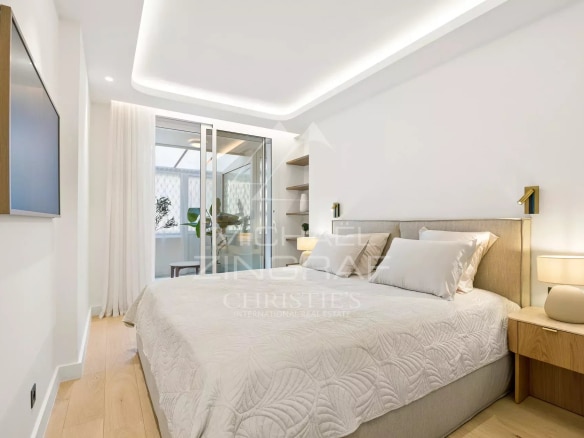 Chambre d'un appartement rénové avec lit double et décoration moderne à Cannes.