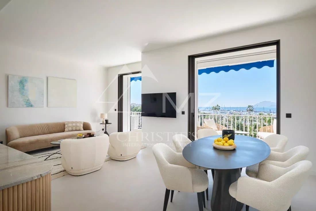 Appartement rénové à Cannes Intérieur d'un appartement rénové à Cannes avec vue sur la mer, salon lumineux et salle à manger.