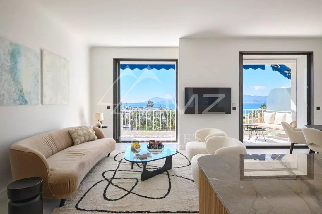 Appartement rénové à Cannes Intérieur d'un appartement rénové à Cannes avec vue sur la mer, salon lumineux et terrasse.