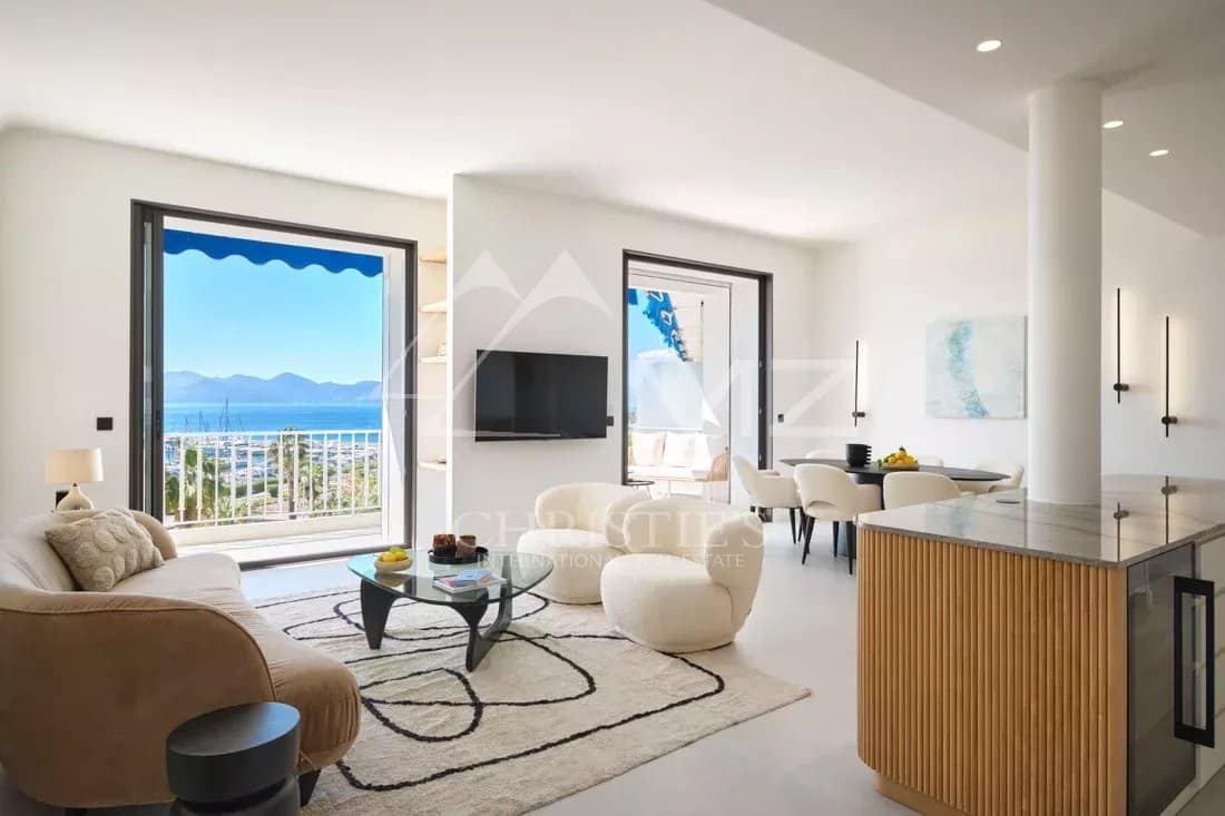 Appartement rénové à Cannes Intérieur d'un appartement rénové à Cannes avec vue sur la mer, salon lumineux et cuisine moderne.