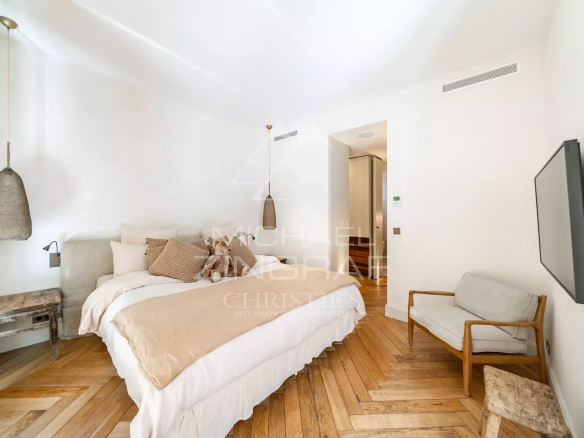 Chambre d'un appartement élégant avec lit double et décoration moderne.