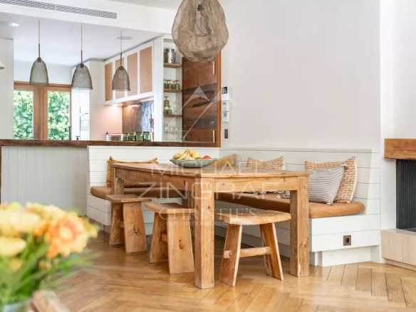 Intérieur d'un appartement avec une salle à manger en bois et une cuisine ouverte.