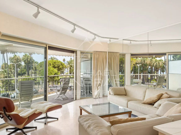 Intérieur d'un appartement à Cannes avec salon lumineux et terrasse face à la mer.