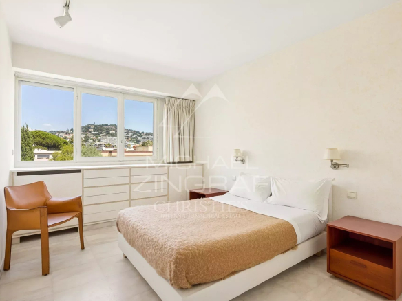 Chambre d'un appartement à Cannes avec lit double et vue sur la mer.