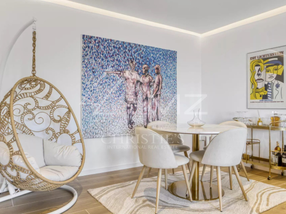 Intérieur d'un appartement moderne avec une décoration artistique, incluant une table à manger et un fauteuil suspendu.