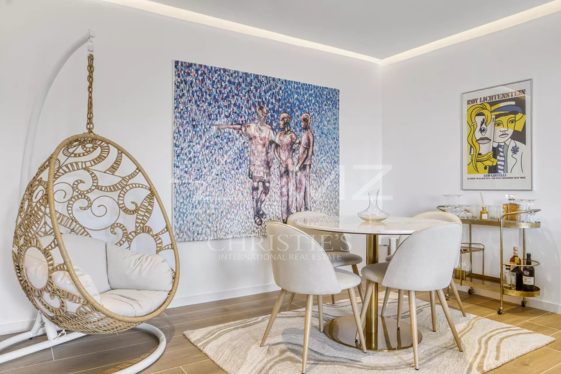 Intérieur d'un appartement moderne avec une décoration artistique, incluant une table à manger et un fauteuil suspendu.